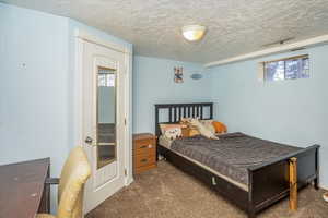 Carpeted bedroom featuring a textured ceiling