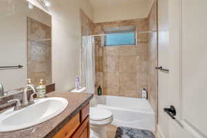 Apartment has a full bathroom with shower / tub combo, vanity, toilet, and tile patterned floors