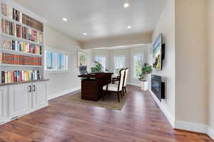 Home office with dark wood-type flooring and a wealth of natural light