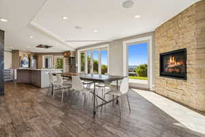 Dining area featuring hardwood / wood-style flooring and a stone fireplace