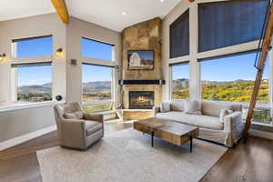 Living room with plenty of natural light, a fireplace, a mountain view, and dark wood-type flooring