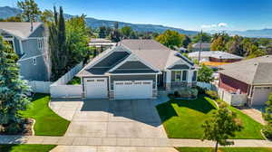 Craftsman house with a mountain view, a garage, and a front lawn