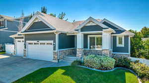 Craftsman-style house featuring a garage and a front lawn