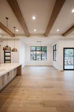 Interior space featuring plenty of natural light, beamed ceiling, and light hardwood / wood-style flooring