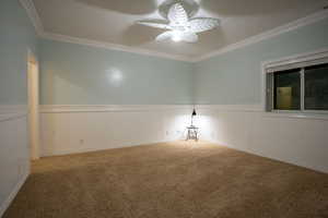 Carpeted spare room with ornamental molding and ceiling fan