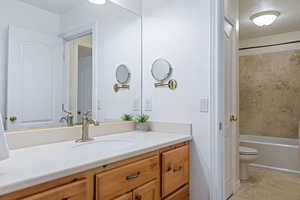 Full bathroom featuring vanity, a textured ceiling, washtub / shower combination, tile patterned flooring, and toilet