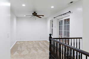 Carpeted spare room with ceiling fan