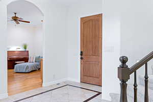 Entrance foyer with crown molding, light hardwood / wood-style floors, and ceiling fan