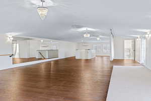 Unfurnished living room with an inviting chandelier and hardwood / wood-style floors