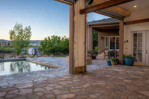 Pool at dusk featuring a patio area