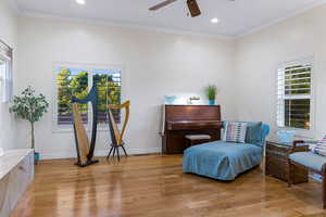 Sitting room featuring ornamental molding, light hardwood / wood-style floors, and ceiling fan