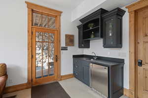 Interior space featuring stainless steel refrigerator, light colored carpet, and sink