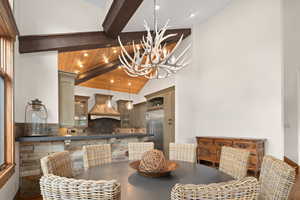 Dining area featuring an inviting chandelier, vaulted ceiling with beams, hardwood / wood-style flooring, and wooden ceiling