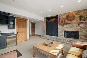 Carpeted living room with bar area and a fireplace