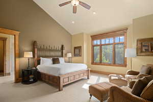 Bedroom featuring high vaulted ceiling, ceiling fan, and light colored carpet