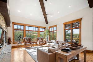 Living room featuring light wood-type flooring, lofted ceiling with beams, and a wealth of natural light