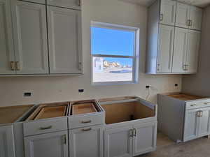 Kitchen featuring white cabinetry and light hardwood / wood-style flooring