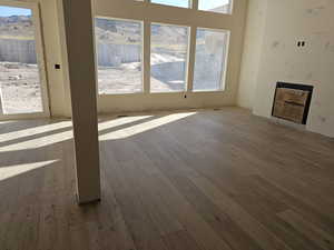 Unfurnished living room with light hardwood / wood-style flooring and a mountain view