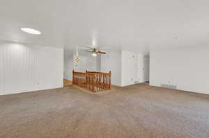 Unfurnished living room with ceiling fan, carpet floors, and a textured ceiling