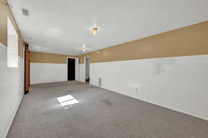 Carpeted spare room featuring a textured ceiling