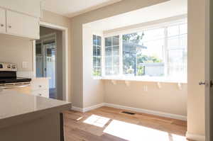 Kitchen featuring a wealth of natural light, white range with electric cooktop, and white cabinets