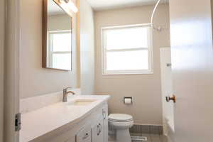 Full bathroom with vanity, bathtub / shower combination, toilet, and tile patterned floors