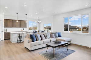 Living room with light hardwood / wood-style floors and a chandelier