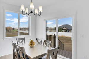 Dining space featuring wood-type flooring, a notable chandelier, and plenty of natural light