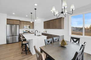 Dining room with sink, a notable chandelier, and hardwood / wood-style flooring