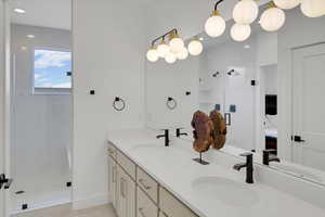 Bathroom featuring tile patterned floors, vanity, and a shower with door