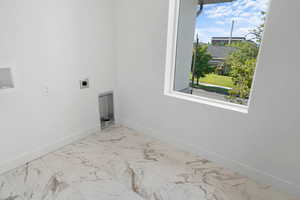 Clothes washing area featuring hookup for an electric dryer