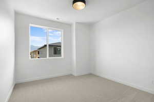 Unfurnished room featuring light colored carpet