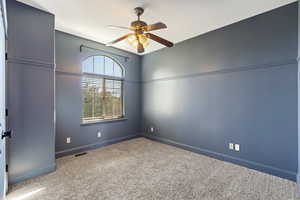 Spare room with ceiling fan and carpet floors