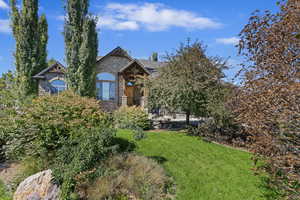 View of property hidden behind natural elements with a front yard