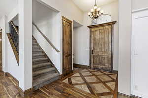 Foyer entrance with a chandelier and dark wood-type flooring