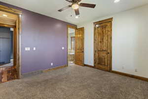 Unfurnished bedroom with ceiling fan and dark colored carpet