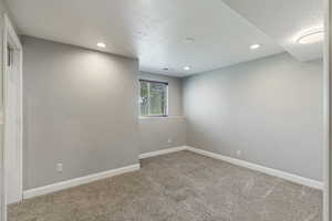 Carpeted empty room featuring a textured ceiling