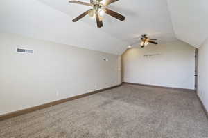 Interior space with carpet flooring, vaulted ceiling, and ceiling fan