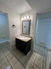 Full bathroom with separate shower and tub, tile patterned flooring, vanity, and toilet