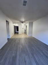 Unfurnished living room featuring ceiling fan and light hardwood / wood-style flooring