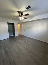 Unfurnished bedroom with ceiling fan, a closet, and dark hardwood / wood-style flooring