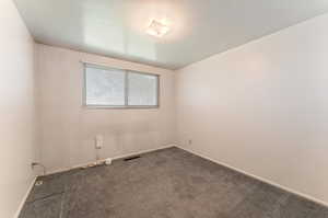 2nd bedroom on main floor featuring dark carpet