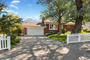 View of front of property with a mountain view, a front yard, and a 2 car garage