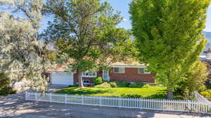 View of property hidden behind natural elements featuring a garage