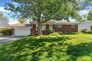 Single story home with a 2 car garage and a front lawn