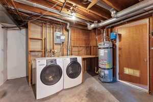 Clothes washing area featuring water heater, electric panel, and independent washer and dryer