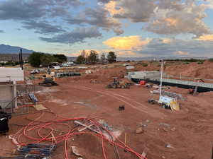 From rooftop patio, overlooking where a large 12-slided splash pad will be, terraced lounge chairs, and the wave machine (part of the action river is visible towards the back.