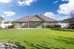 Back of property with a lawn and a patio area