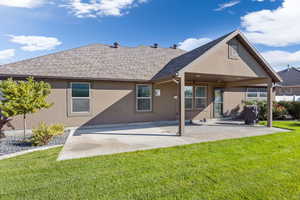 Rear view of property featuring a patio and a yard