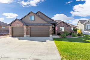 View of front of property featuring a front lawn and a garage